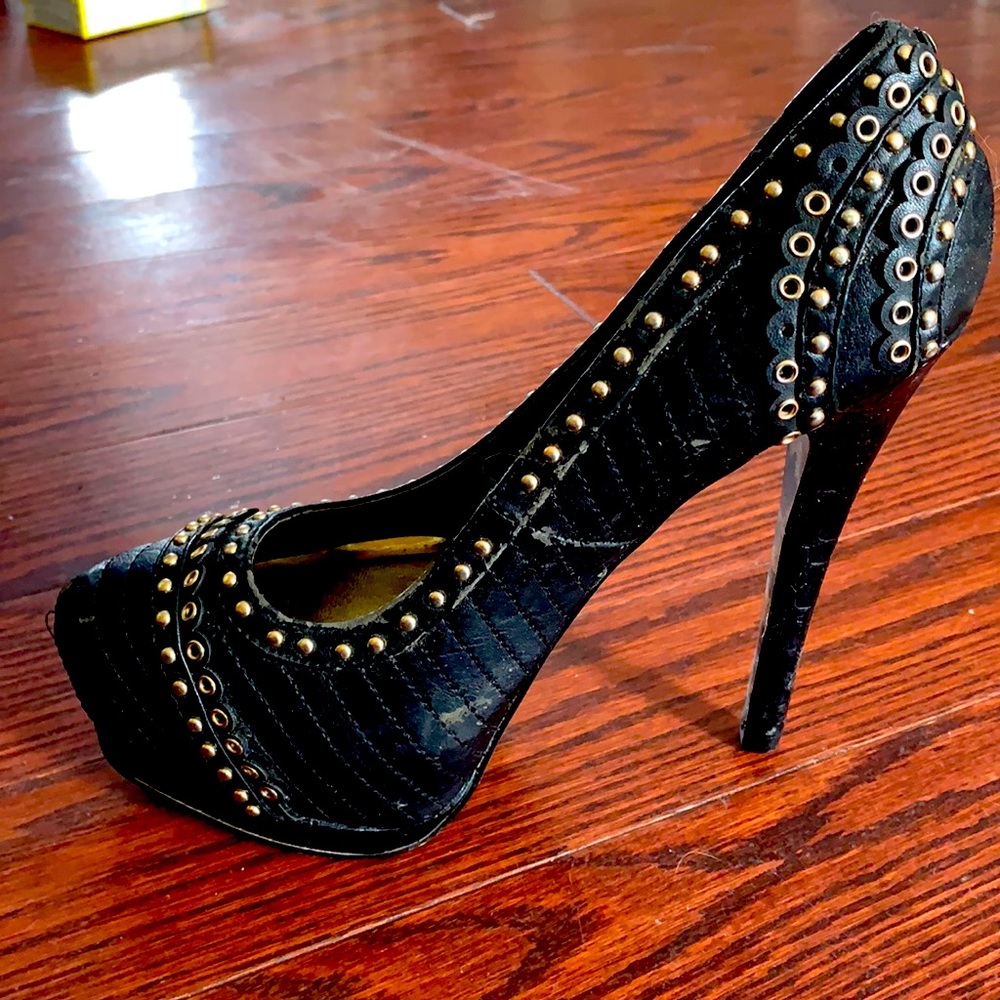 Very high black heels with gold detail.